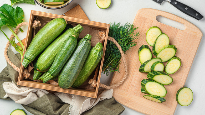 Whole zucchini next to zucchini slices