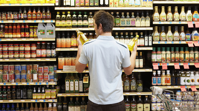 person comparing products at a grocery store aisle