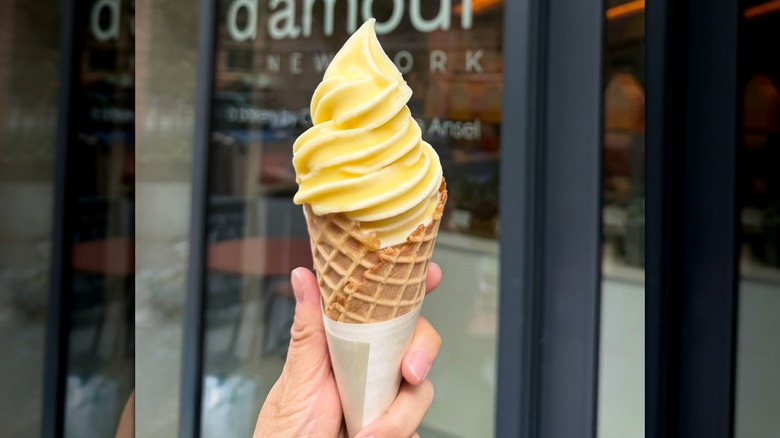 A hand holds up butter-dipped soft serve ice cream.