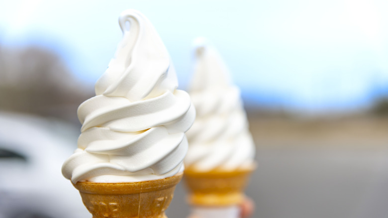 Two soft-serve vanilla ice cream cones.