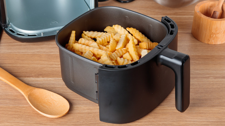 Air fryer bin with french fries in it.