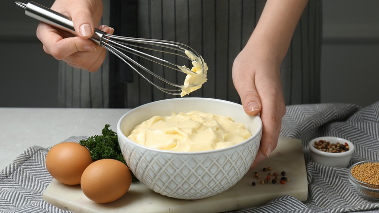 Person whisking mayonnaise in bowl