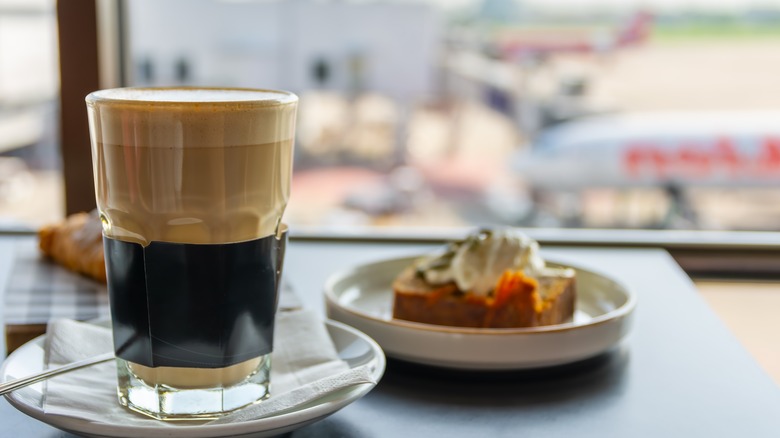 A coffee and pastry with a view of a plane