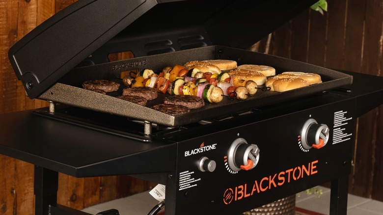 Blackstone grill with burgers, kebabs and buns