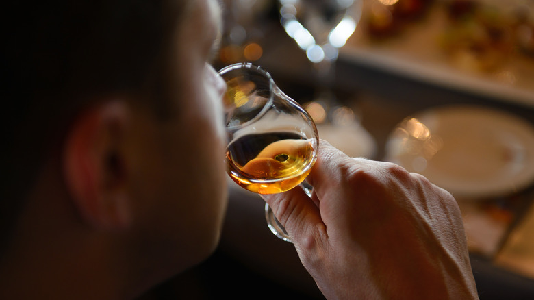 Person smelling and tasting whiskey