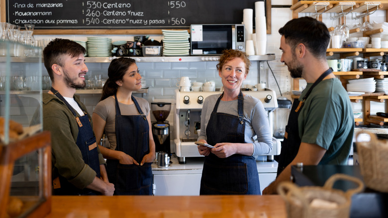 Several restaurant employees behind a counter.