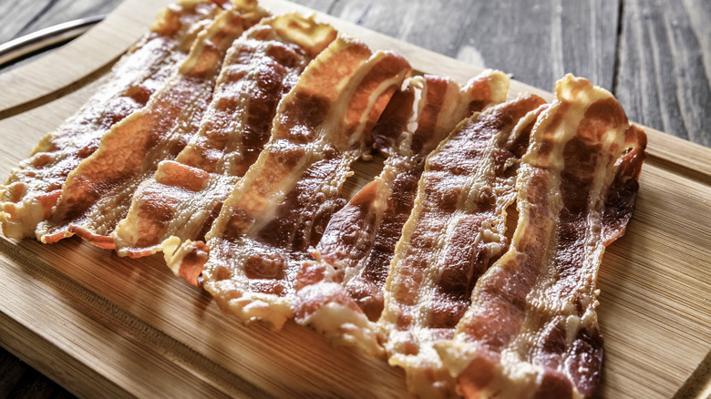 Strips of cooked bacon on a cutting board