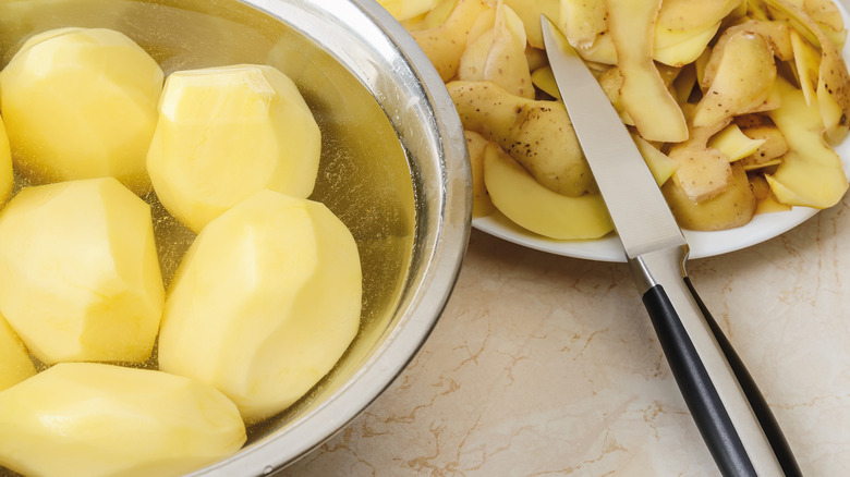 Peeled potatoes in a bowl of water