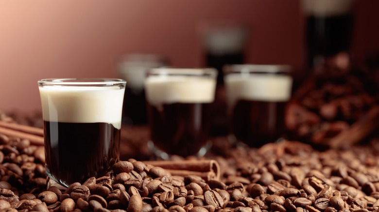 Shots of Kahlúa with cream on a bed of coffee beans