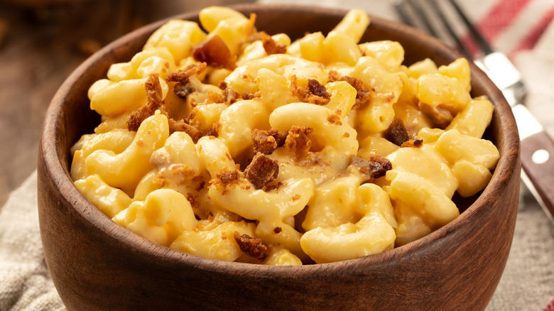 Mac and cheese with bacon in wooden bowl