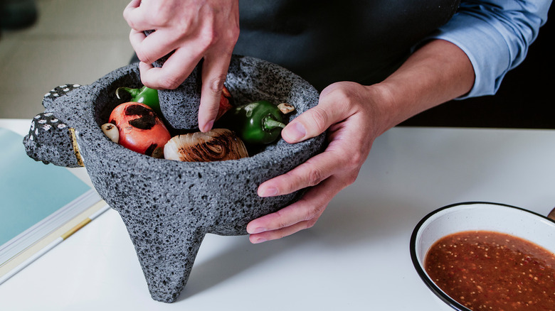 grinding ingredients in the molcajete