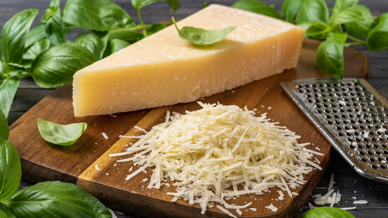 Block of Parmesan and basil leaves