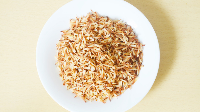 toasted coconut flakes displayed on white bowl
