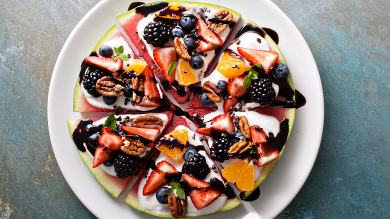 Watermelon pizza with fruit, pecans, yogurt, chocolate sauce