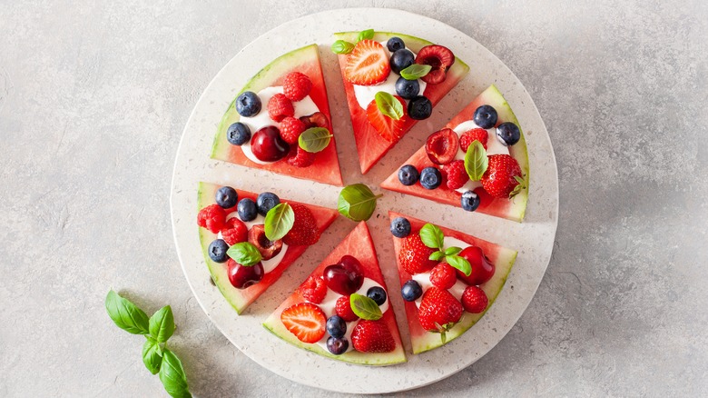 Watermelon pizza with berries cut in triangles
