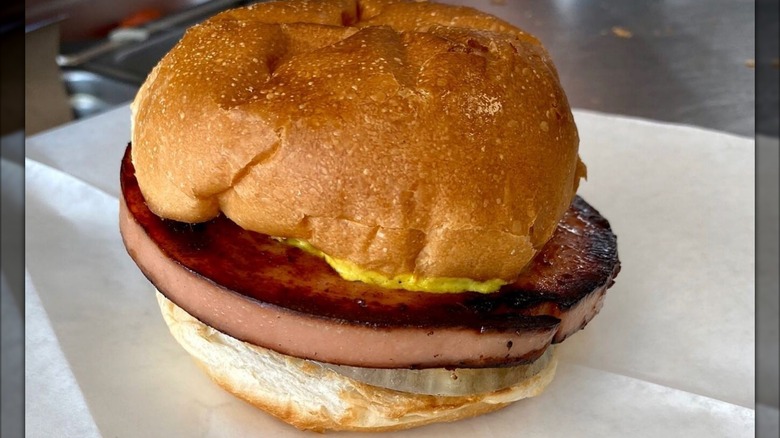 prepared bologna burger with mustard and onion.