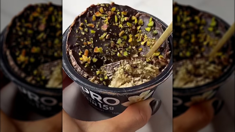 hand holding yogurt cup with Dubai chocolate topping