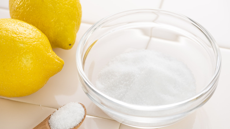 Lemons alongside bowl of citric acid
