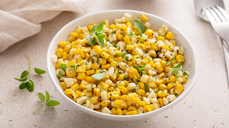 A corn salad in a bowl sitting on a table