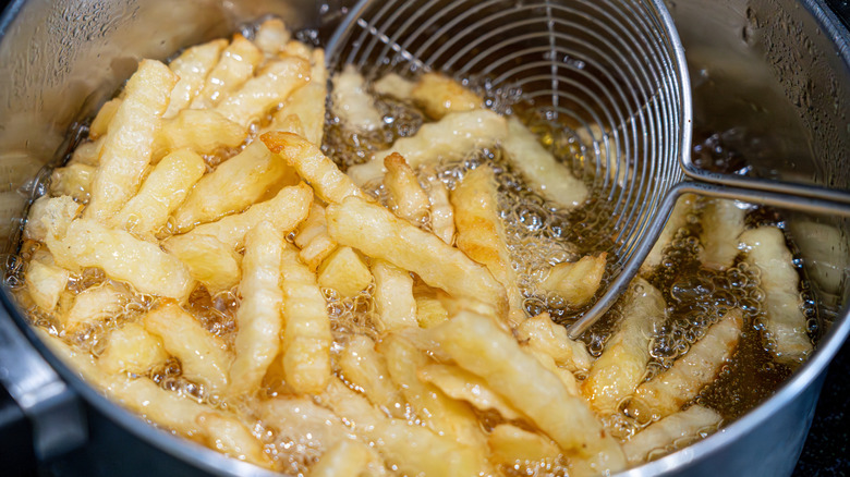 french fries cooking in fryer