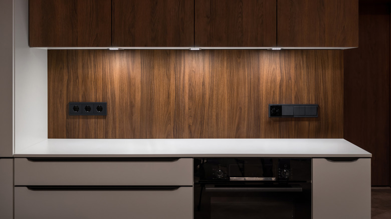 Under-cabinet lighting shines down on a modern kitchen countertop