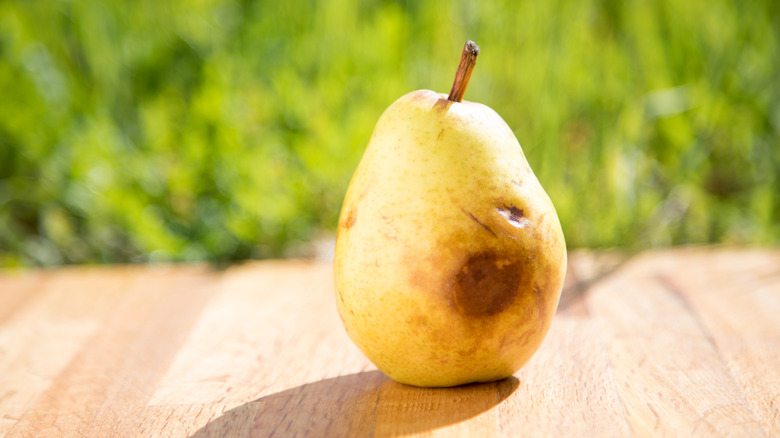 Bruised pear on wooden table