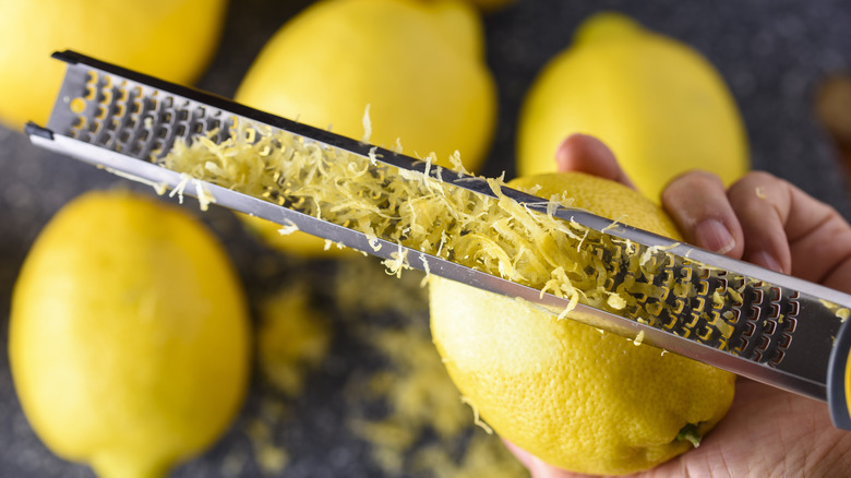 Person zesting lemon with microplane