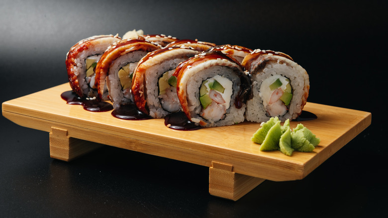Wooden platter with sushi roll and wasabi