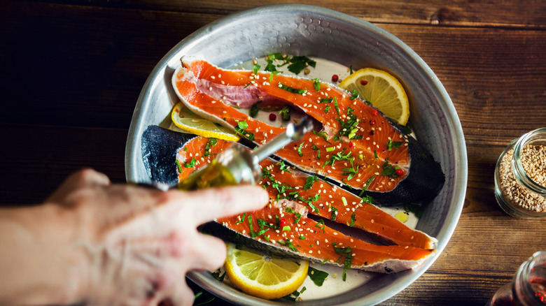 Raw salmon with sliced lemons ready to be put in the oven.