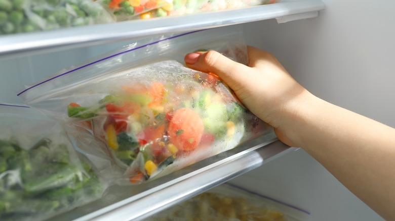 Person taking frozen veggies out of refrigerator