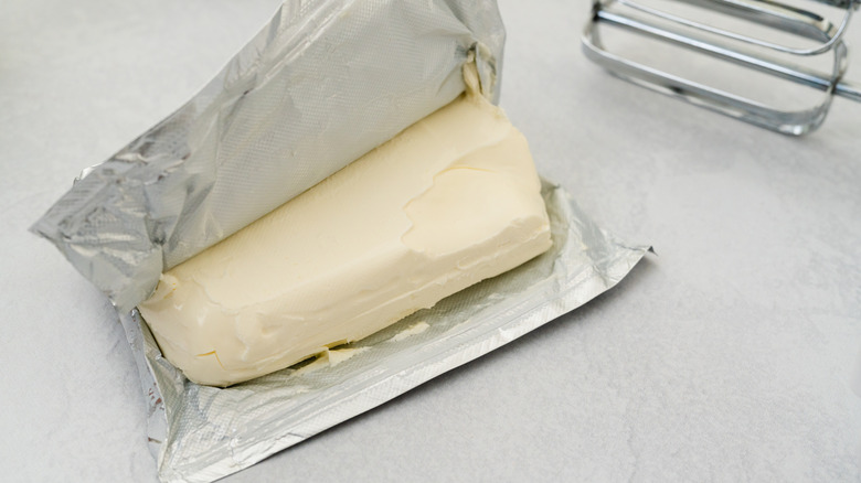 A block of cream cheese unwrapped