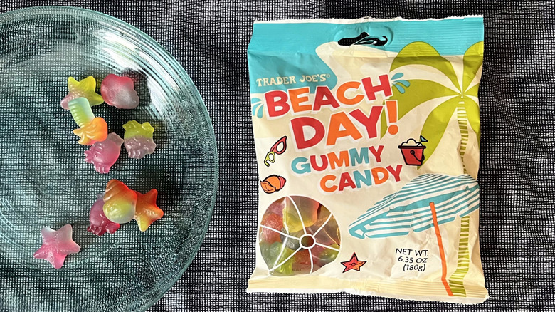 A handful of Trader Joe's Beach Day! Gummy Candy on a glass plate next to a bag of Beach Day! Gummy Candy