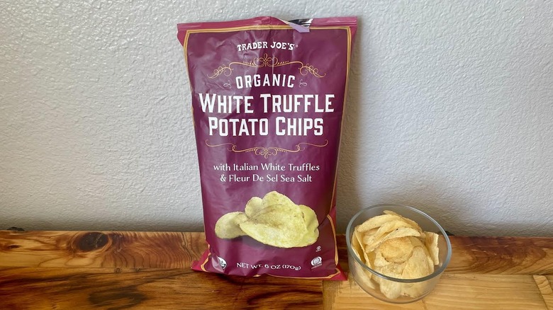 A bag and dish of Organic White Truffle Potato Chips on a wooden table top