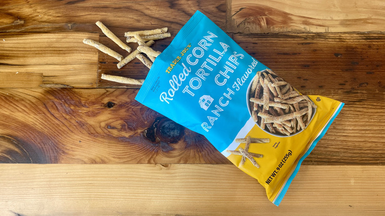 Overhead view of a bag of Ranch Flavored Rolled Corn Tortilla Chips spilling out onto a wooden table top