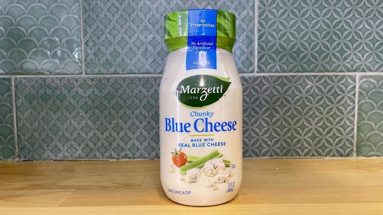 Bottle of Marzetti Chunky Blue Cheese Dressing on wooden countertop