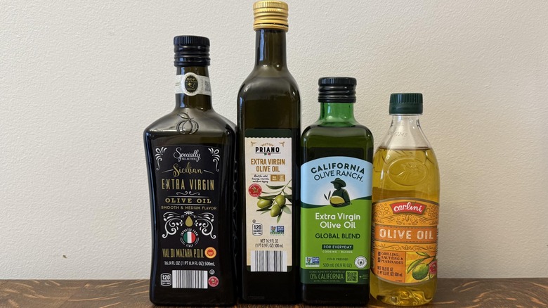 Four different kinds of olive oil against white background