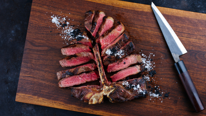 A sliced porterhouse on cutting board