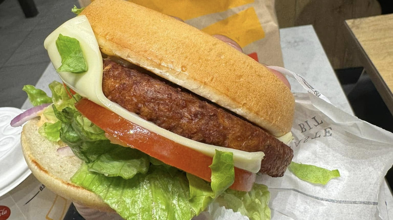 A hand holds a McVeggie burger in a McDonald's in Sweden.