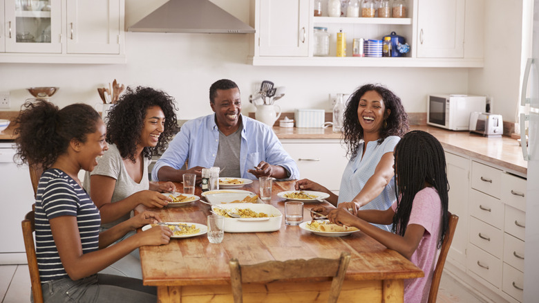 Family laughing at a dinner table