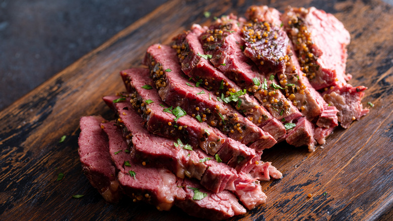 Sliced corned beef on a wooden cutting board