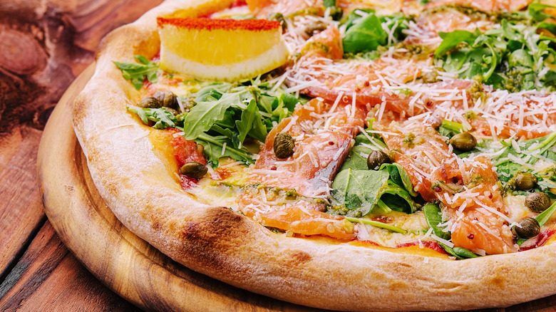 Italian pizza with salmon, capers, lemon, arugula or rocket