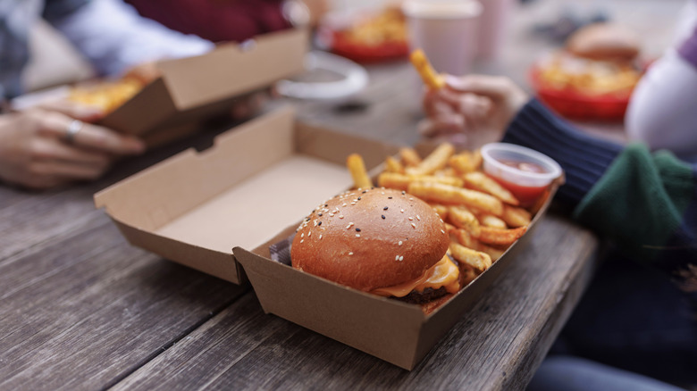Friends eating burgers and fries together.