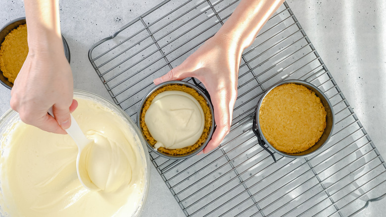 Hands spooning batter into pans