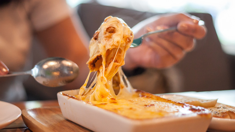 Eating lasagna from dish