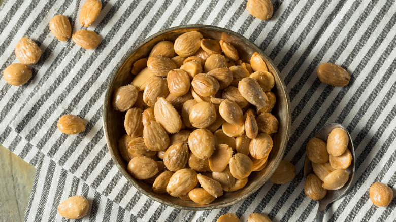 Bowl and spoon of Marcona almonds on striped cloth