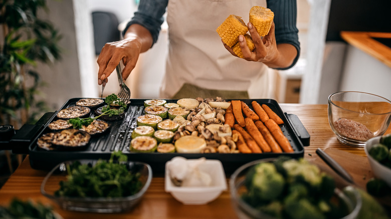 Hands flipping roasted veggies