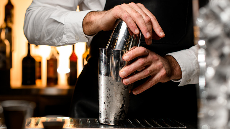 Bartender using a cocktail shaker to make a drink