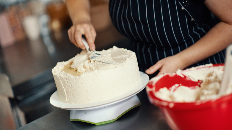 person finishing a layer cake