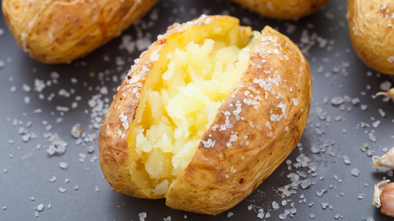 Baked potatoes with crisp salty skin and garlic cloves