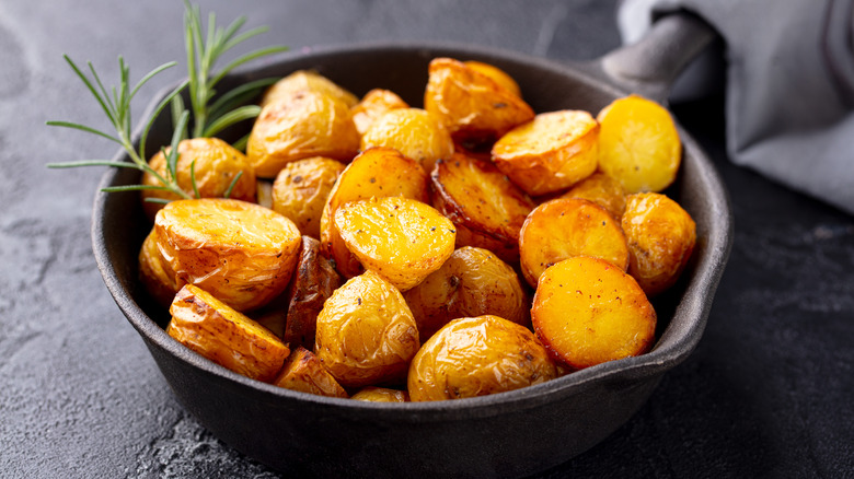 Crispy roast potatoes in black bowl
